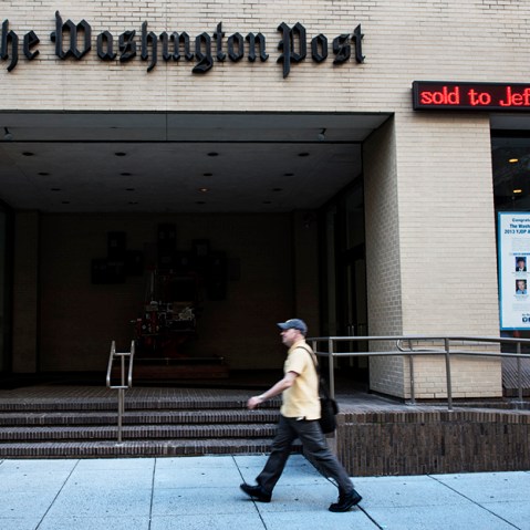 A man walks past The Washington Post building on August 5, 2013 in Washington, DC, after it was announced that Amazon.com founder and CEO Jeff Bezos had agreed to purchase the Post for USD 250 million. (Photo by Brendan Smialowski/AFP/Getty)
