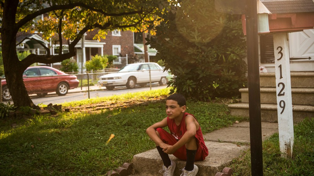 A boy sits on his front steps on August 20, 2013 in the Fairview neighborhood of Camden, New Jersey.