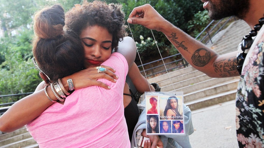 Dejia Ferguson (C), a friend of slain transgender woman Islan Nettles, hugs another mourner before a vigil for her as a man holds photos of Nettles at Jackie Robinson Park in Harlem on Aug. 27, 2013 in New York City.