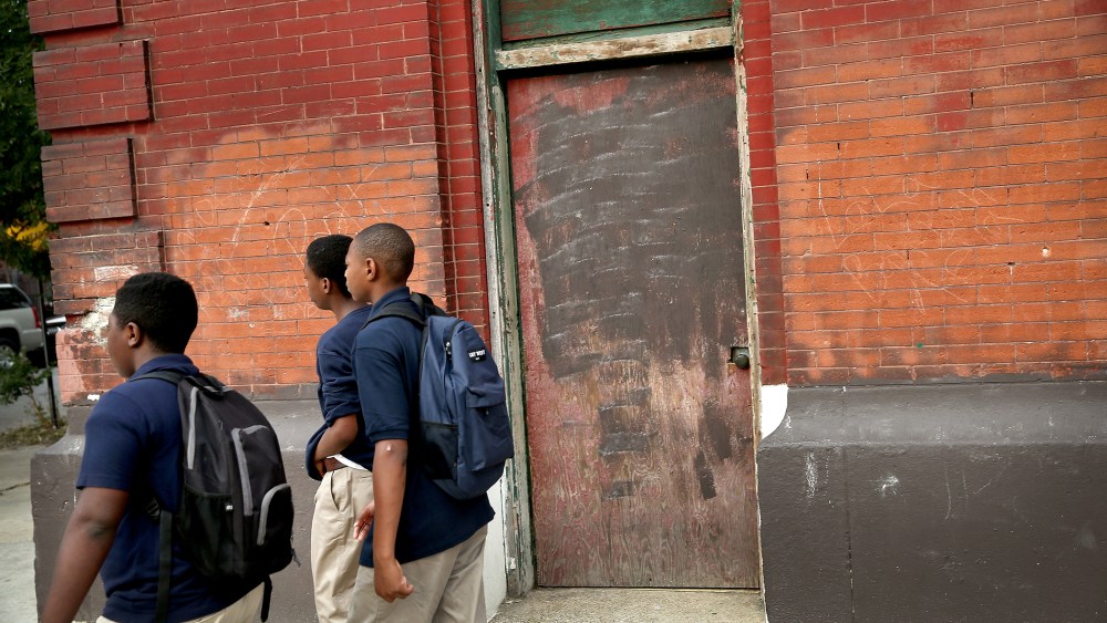 Students walk past an abandoned church building while walking to school on Aug. 28, 2013 in Chicago, Ill.