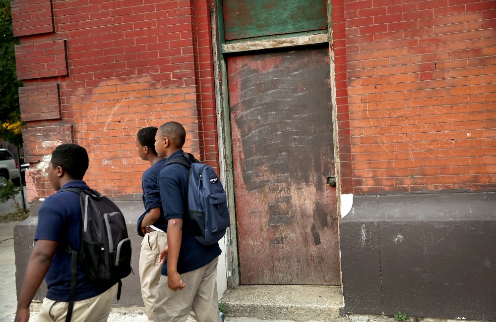 Students walk past an abandoned church building while walking to school on Aug. 28, 2013 in Chicago, Ill.