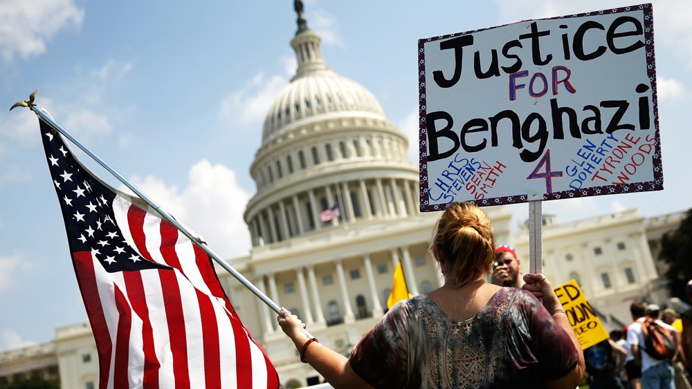 A woman holds signs during a "Call to Action" rally at the U.S. Capitol, marking the one year anniversary of the attacks on the U.S. compound in Benghazi, Sept. 11, 2013.