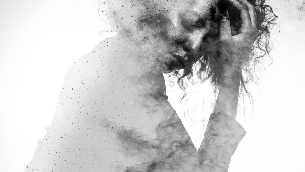 Image: Unhappy woman's form double exposed with paint splatter effect