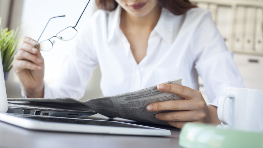 Image: woman reading newspaper