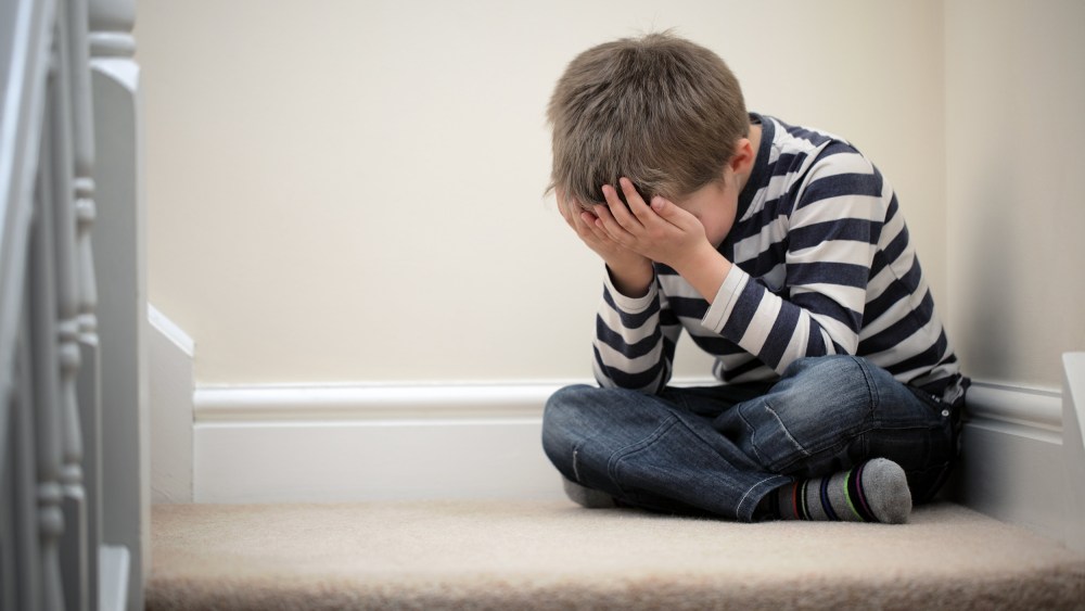 Image: Upset problem child sitting on staircase