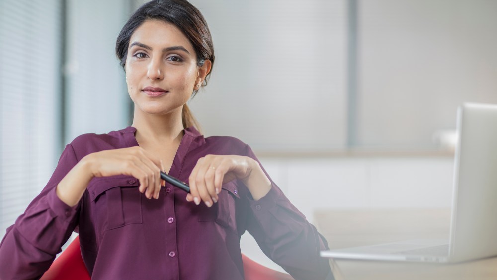 Portrait of confident businesswoman with laptop in office