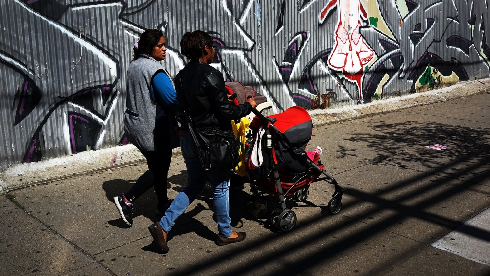 Two women walk down a street in the South Bronx, Sept. 19, 2013.