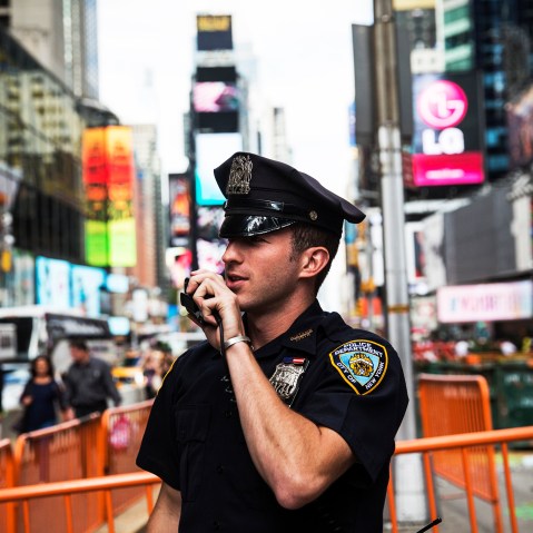 A New York Police Department officer speaks on his radio in Times Square, Sept. 22, 2013.