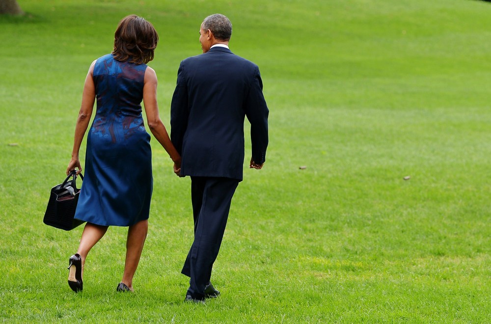 US President Barack Obama and First Lady Michelle Obama make their way to board Marine One on the South Lawn of the White House on September 23, 2013 in Washington, DC.