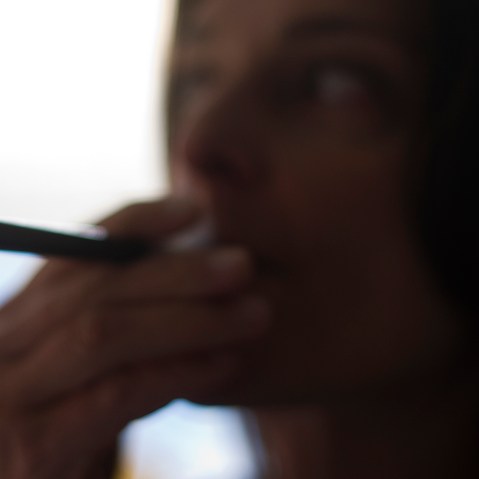 This Sept. 25, 2013 photo illustration taken in Washington, DC, shows a woman smoking an "Blu" e-cigarette (electronical cigarette).