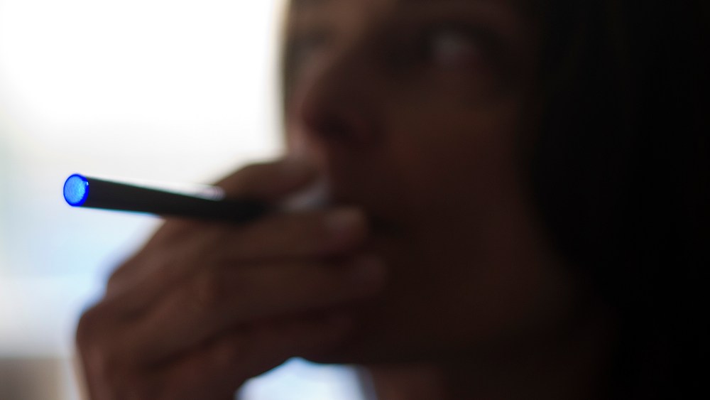 This Sept. 25, 2013 photo illustration taken in Washington, DC, shows a woman smoking an "Blu" e-cigarette (electronical cigarette).