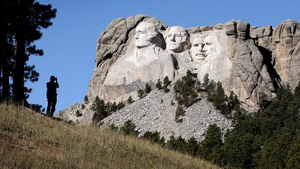 A tourist takes a picture of Mount Rushmore National Memorial from outside the park on Oct. 1, 2013 in Keystone, South Dakota.