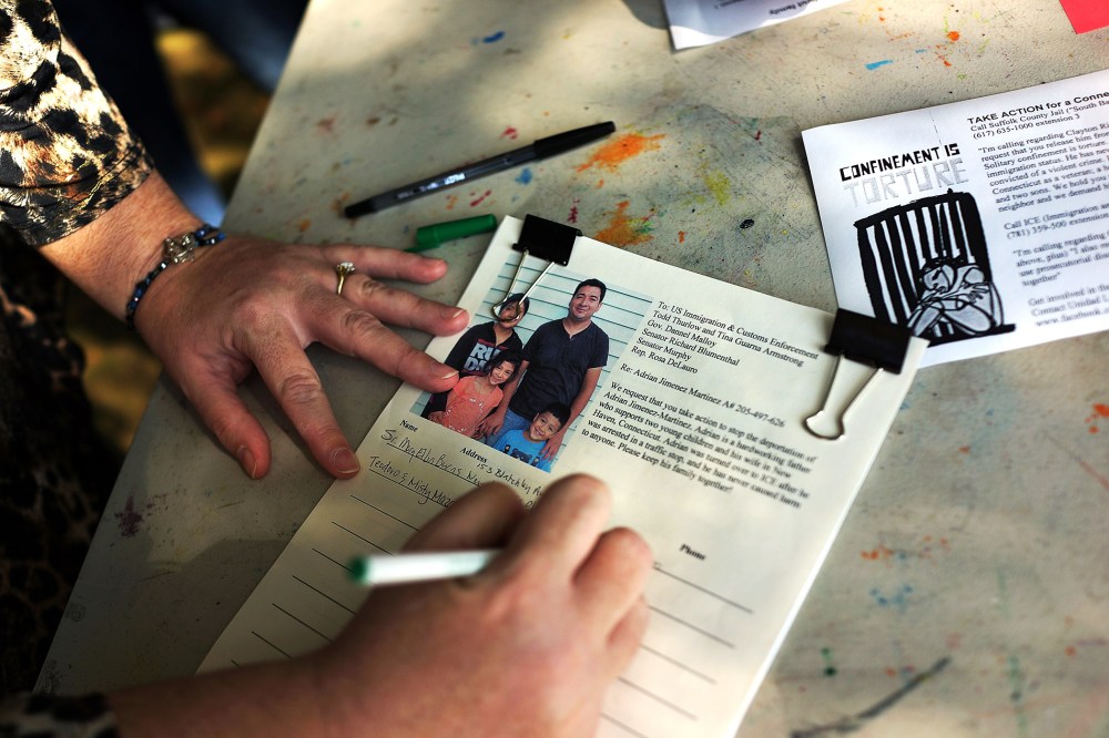 A woman signs a petition in support of a man about to be deported in New Haven, Oct. 5, 2013.