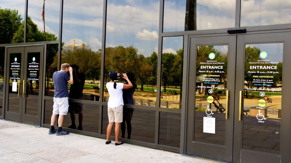 Tourists peer into the closed Smithsonian Air and Space Museum October 5, 2013 in Washington, DC.