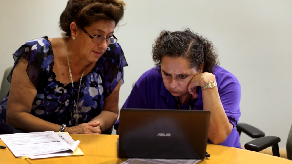 Affordable Care Act navigator Nini Hadwen (R) works with Marta Aguirre as she shops for health insurance during a navigation session put on by the Epilepsy Foundation Florida to help people sign up for health insurance under the Affordable Care Act on Oct