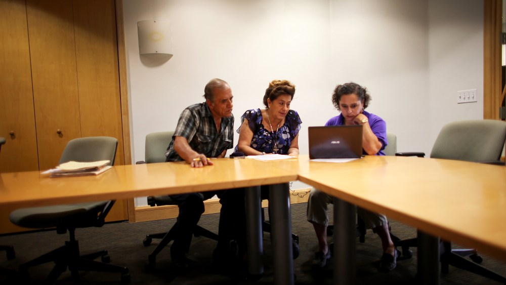Affordable Care Act navigator Nini Hadwen helps Jorge Hernandez and Marta Aguirre as they shop for health insurance in Miami, Florida, October 8, 2013.