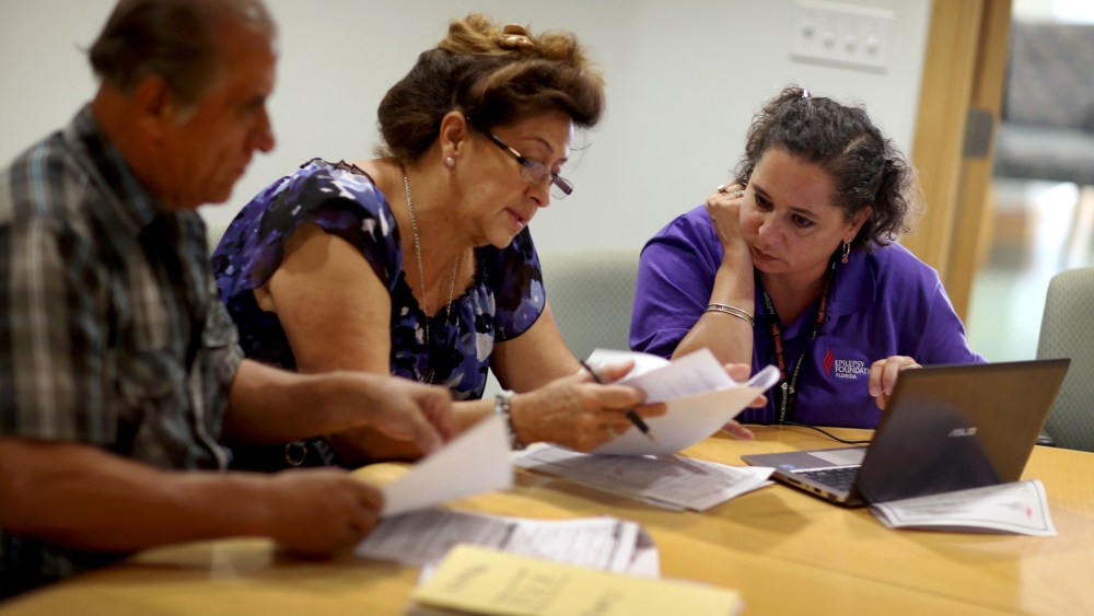 Affordable Care Act navigator Nini Hadwen speaks with Jorge Hernandez and Marta Aguirre as they shop for health insurance.