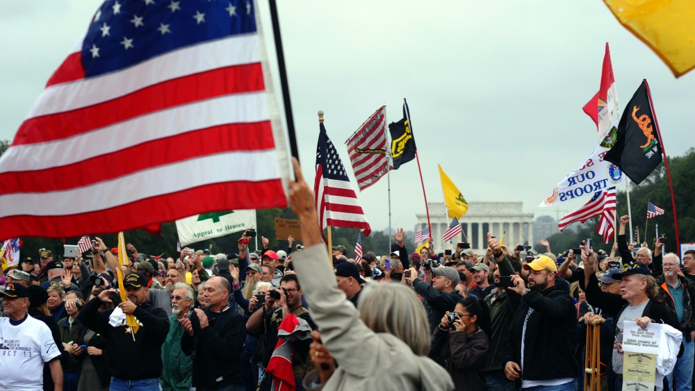 Protesters wave flags during a demonstration at the World War II memorial in Washington, DC, on Oct. 13, 2013 demanding for an end of US federal government shutdown.