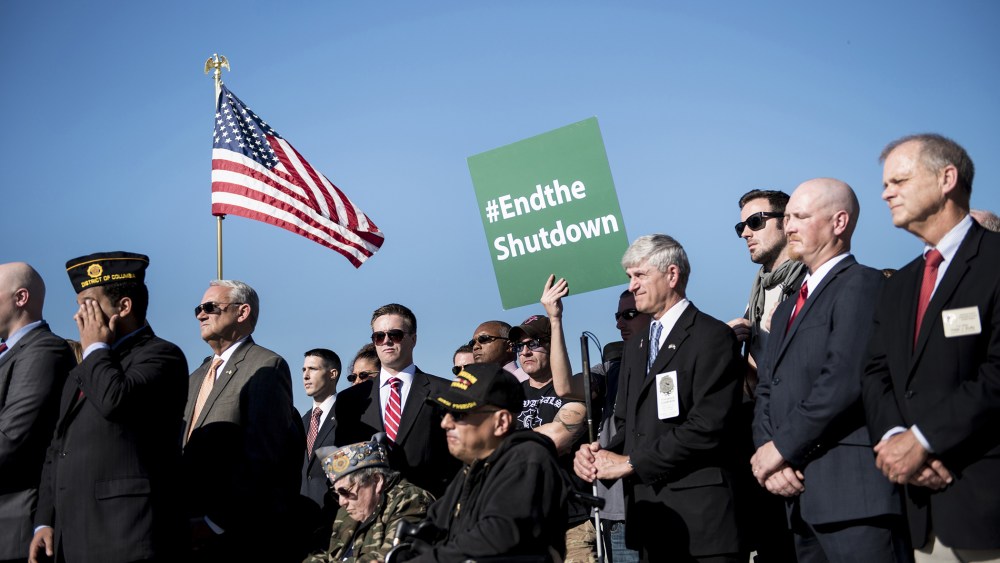 Activists listen to speakers during a rally at the World War II Memorial