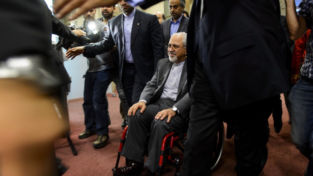 Iranian Foreign Minister Mohammad Javad Zarif leaves with a weelchair a press conference closing a two-day of closed-door nuclear talks on October 16, 2013 in Geneva.