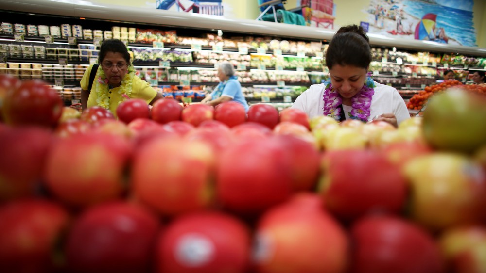 Shoppers look over the produce selection at Trader Joe's in Pinecrest, Fla.