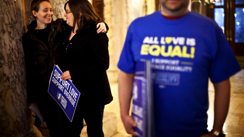 Lauren and Katelynn hug each other as they attend the first massive gay wedding ceremonies at City Hall in the early morning hours of October 21, 2013 in Newark, New Jersey.