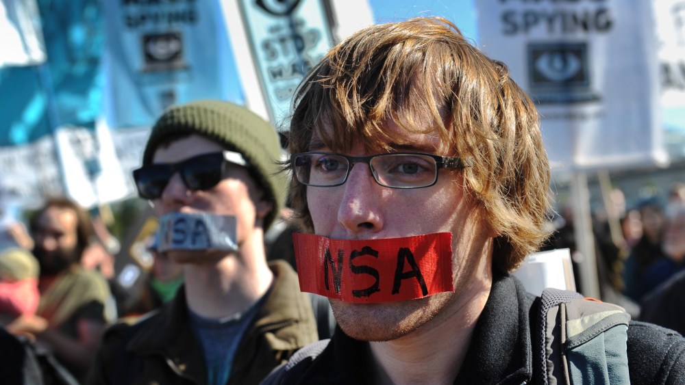 Demonstrators with tape over their mouths take part in a protest against government surveillance on October 26, 2013 in Washington, DC.