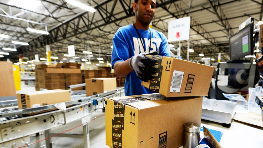 Employee Lamar Roby prepares shipping orders at Amazon's San Bernardino Fulfillment Center October 29, 2013 in San Bernardino, California.