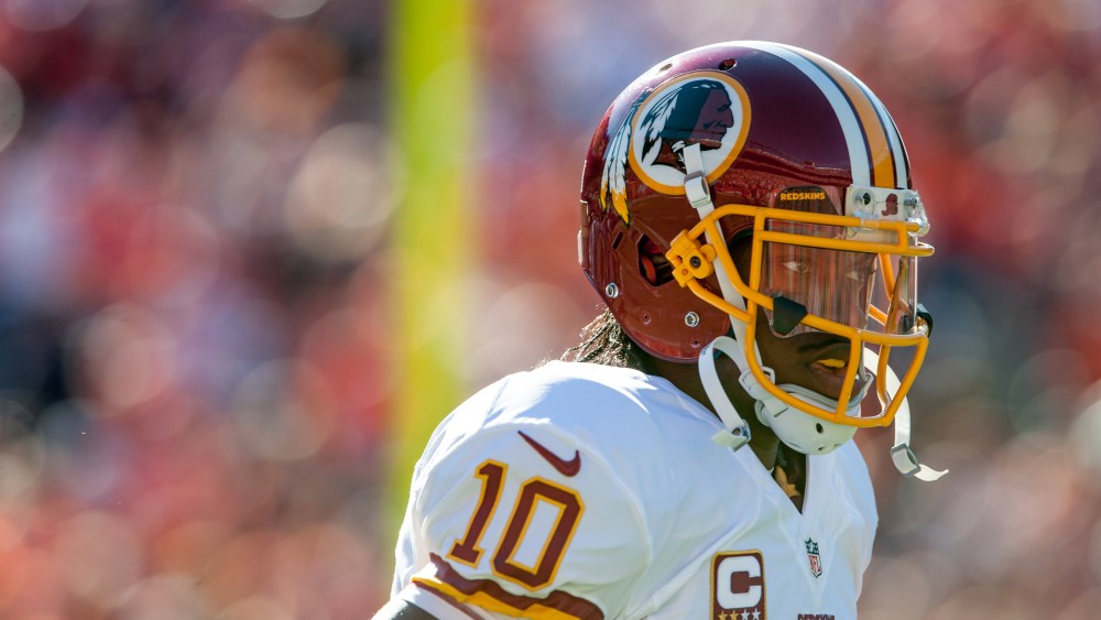 Quarterback Robert Griffin III of the Washington Redskins runs onto the field before a game against the Denver Broncos on October 27, 2013 in Denver, Colorado.