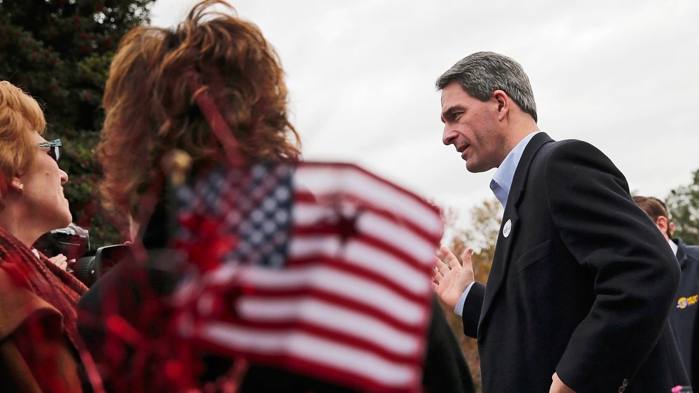 Virginia Attorney General Ken Cuccinelli talks with supporters while greeting voters on Election Day, November 5, 2013 in Mechanicsville, Virginia.