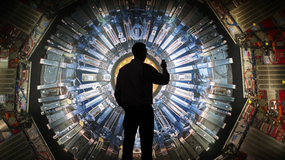 A visitor takes a photograph of an image of the Large Hadron Collider (LHC) at the  Science Museum's 'Collider' exhibition on November 12, 2013 in London, England.