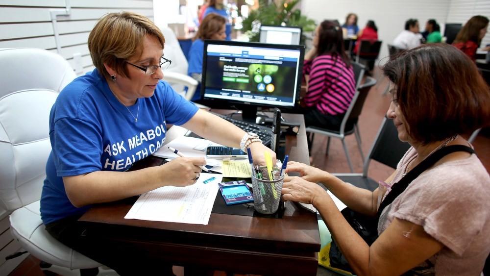Mercy Cabrera (L), an insurance agent with Sunshine Life and Health Advisors, helps Amparo Gonzalez  purchase an insurance policy under the Affordable Care Act at the store setup in the Westland Mall on Nov. 14, 2013 in Hialeah, Fla.