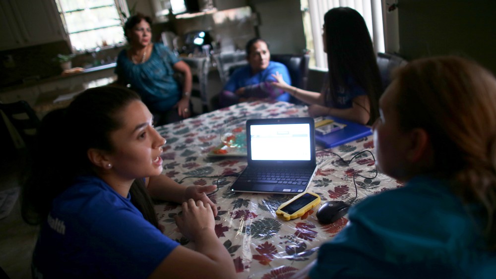 Insurance agent Janelle Arevalo makes a house call to sign up Sandra Berrios for a plan under the ACA in Miami, Nov. 14, 2013.