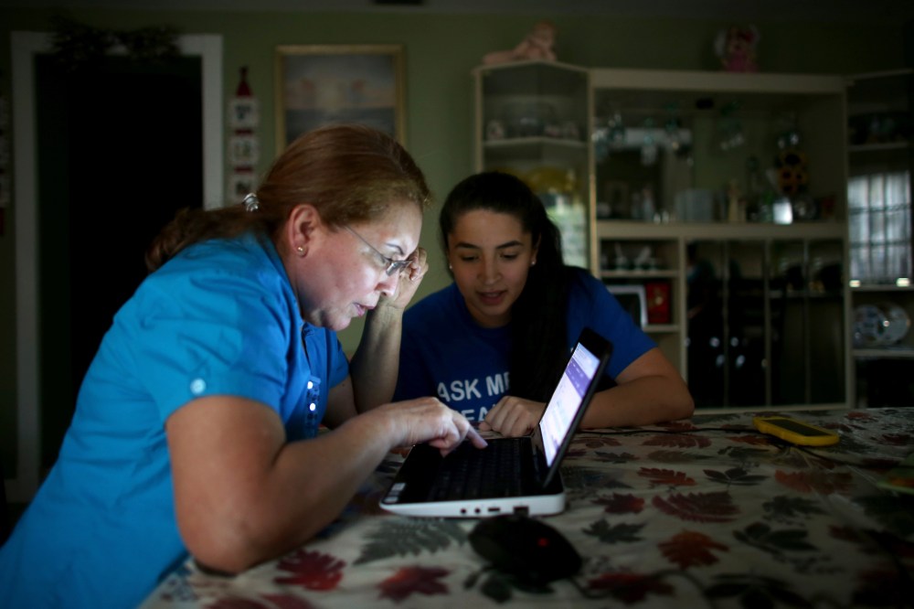 Janelle Arevalo (R), an insurance agent with Sunshine Life and Health Advisors, makes a house call to sign up Sandra Berrios for an insurance plan under the Affordable Care Act on Nov. 14, 2013 in Miami, Fla.