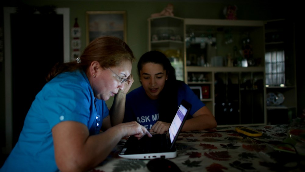 Janelle Arevalo (R), makes a house call to sign up Sandra Berrios for an insurance plan under the Affordable Care Act on Nov. 14, 2013 in Miami, Fla.