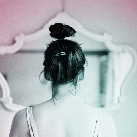 Young woman looking in the mirror