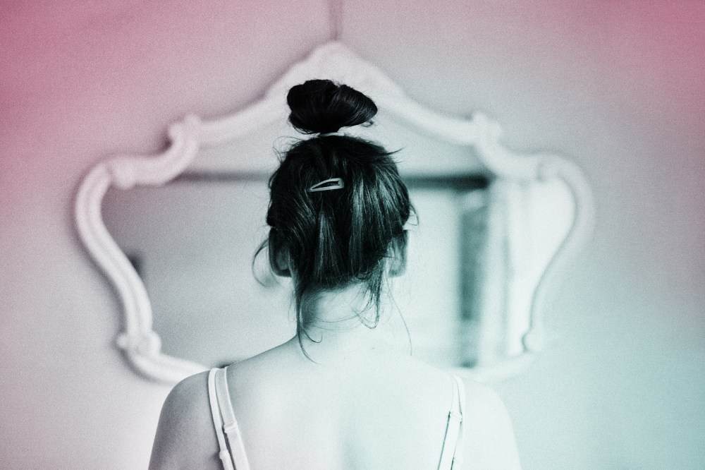 Young woman looking in the mirror