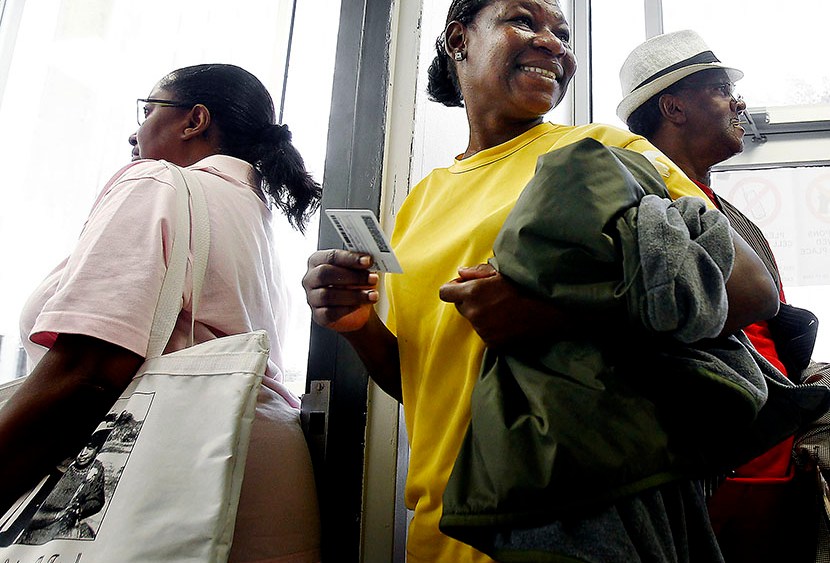 Chantell Wallace (middle) holds out her ID while waiting in line with fellow Shelby County residents during the first day of early voting, October 17, 2012 in Memphis, TN  (Photo by Mark Weber/The Commercial Appeal/ZUMAPRESS.com)