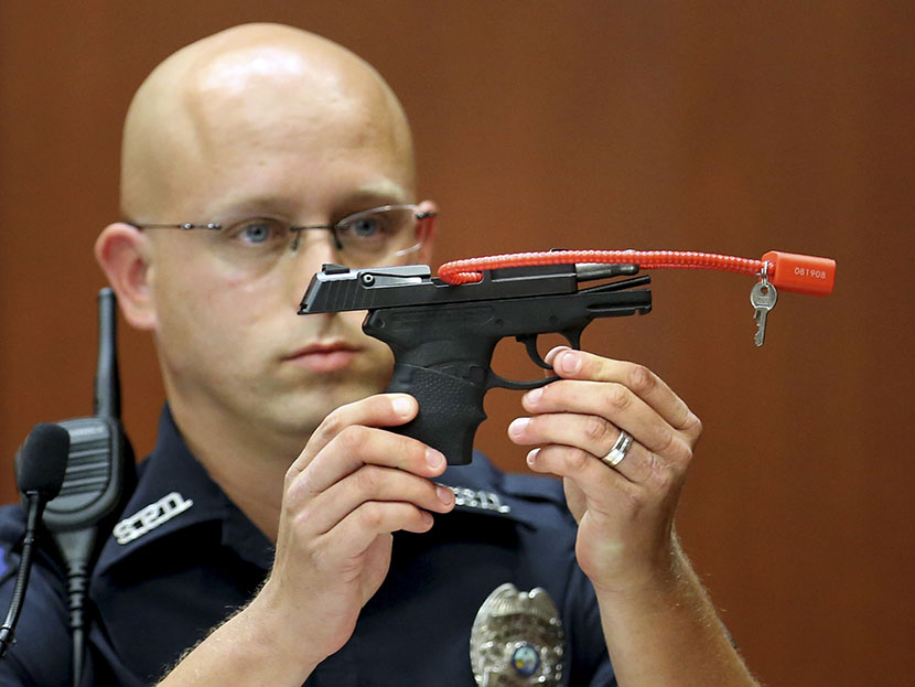 Sanford police officer Timothy Smith holds up the gun that was used to kill Trayvon Martin, while testifying during George Zimmerman's murder trial in Seminole circuit court in Sanford, Florida, June 28, 2013. (Photo by Joe Burbank/Reuters)