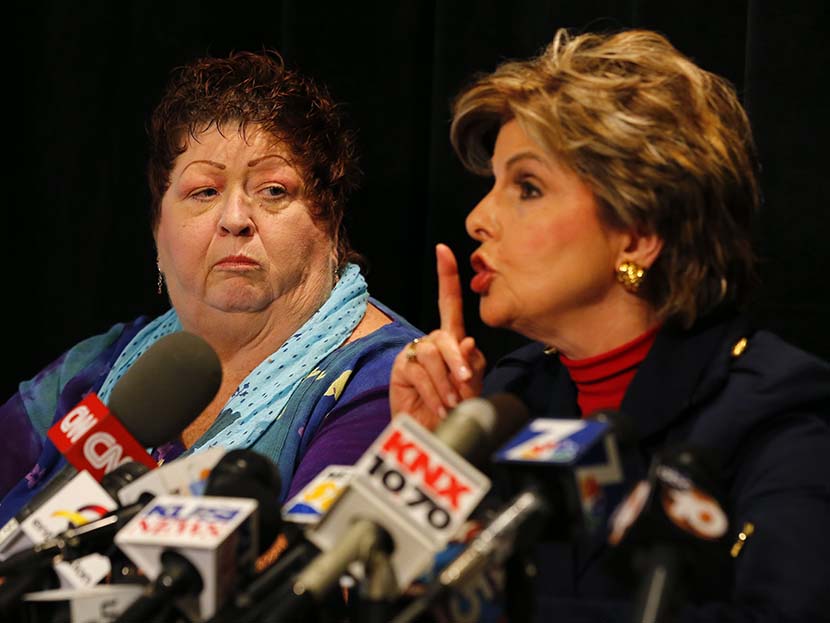 Great-grandmother and senior citizen Peggy Shannon, who works at the Senior Citizens Service Desk in San Diego City Hall, looks on as her attorney Gloria Allred mimics a gesture Mayor Bob Filner previously made towards her during a news conference in...