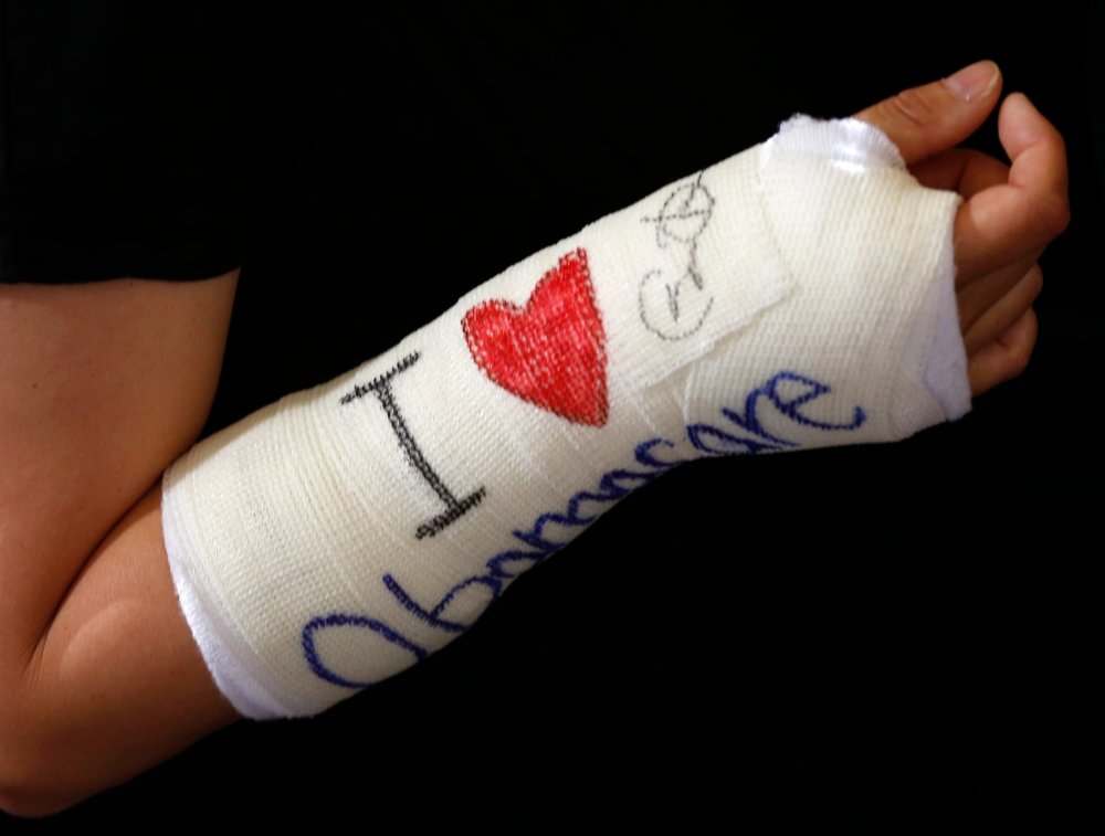 Cathey Park of Cambridge, Massachusetts shows her cast signed by U.S. President Barack Obama after he spoke about health insurance at Faneuil Hall in Boston, October 30, 2013.