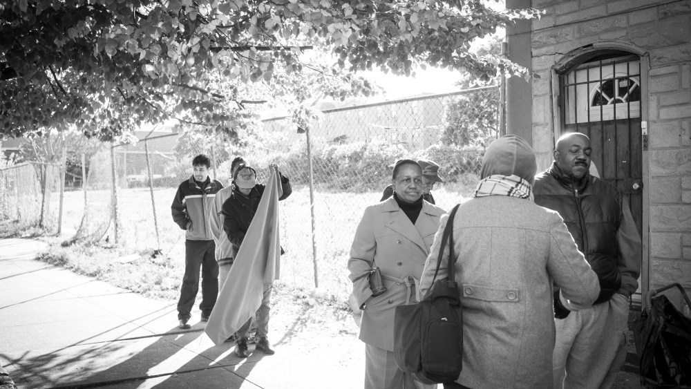People wait in line along Fulton Street for the opening of the Bed-Stuy Campaign Against Hunger.