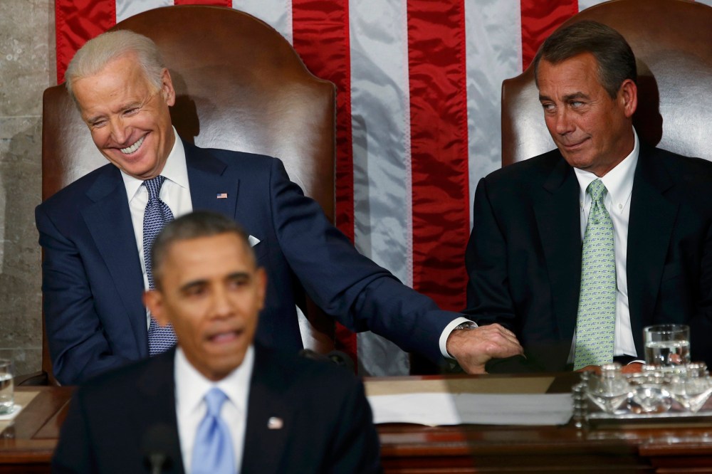 U.S. Vice President Joe Biden (L) grabs the arm of House Speaker John Boehner (R-OH) as President Barack Obama delivers his State of the Union address in front of the U.S. Congress, on Capitol Hill in Washington, Jan. 28, 2014.