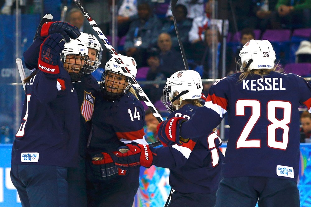 Team USA's Kacey Bellamy (2nd from L) is congratulated by teammates after scoring against Sweden during the first period of their women's semi-final ice hockey game at the 2014 Sochi Winter Olympics, Feb. 17, 2014.