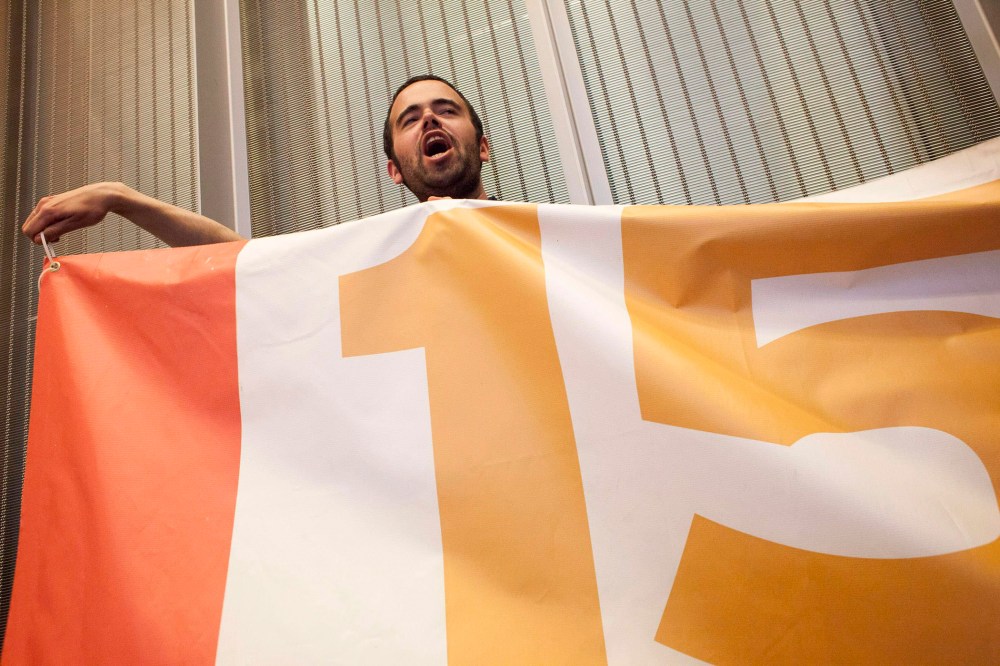 Liam Collinane cheers during a Seattle City Council meeting before the council's vote on raising the minimum wage to $15 per hour in Seattle, Washington on June 2, 2014.