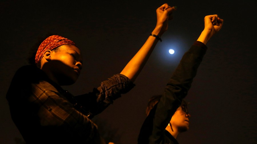 Demonstrators raise their hands during a moment of silence on the campus of Saint Louis University in St. Louis, Missouri early October 13, 2014. (Shannon Stapleton/Reuters)