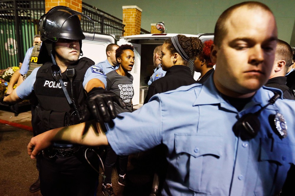 Police set up a perimeter around a protester who is detained during a demonstration at a Walmart store in St. Louis, Mo. on Oct. 13, 2014.