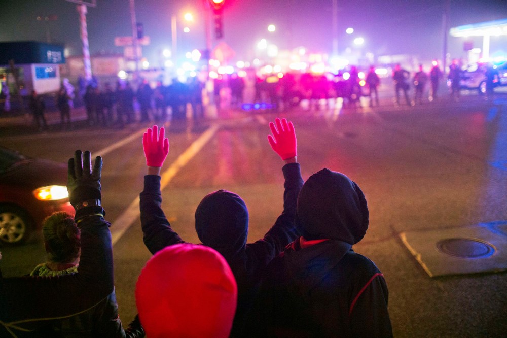 Protesters confront police officers during a second night of rioting in Ferguson, Mo. on Nov. 25, 2014. (Photo by Lucas Jackson/Reuters)