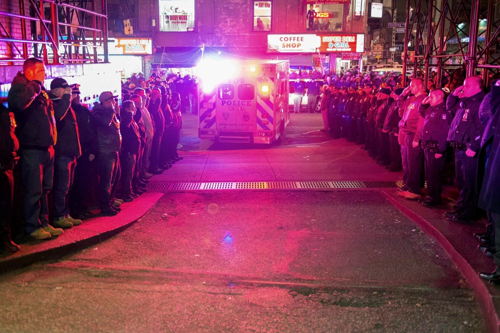 Police officers salute as vehicles containing the bodies of two New York Police officers who were shot dead drive by in Brooklyn on Dec. 20, 2014. (Stephanie Keith/Reuters)