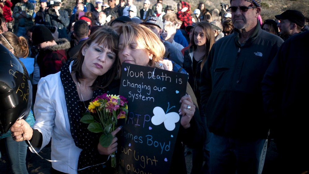 Star Garrett, left, and Shannon Haley, second from left, embrace during the vigil for James Boyd Albuquerque on April 2, 2014.
